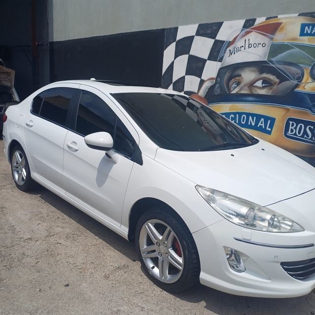 Peugeot branco lavado em frente à loja, com mural ao fundo